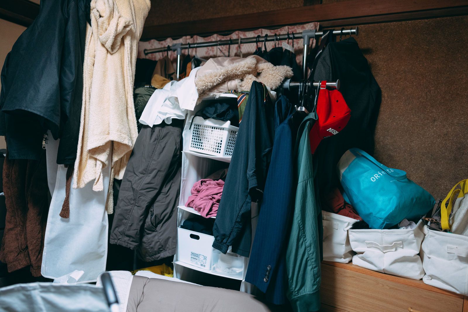 衣類で散らかった実家の部屋の写真