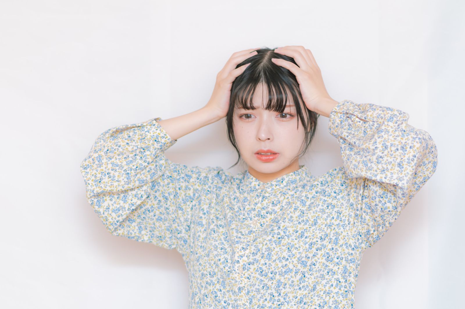 頭を抱えて落ち込む女性（遺品整理でうつ・無気力のイメージ）